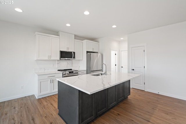 11116 NE 91st Ave, Vancouver, WA 98662 - kitchen featuring a kitchen island with sink, wood finished floors, a sink, white cabinets, and stainless steel appliances