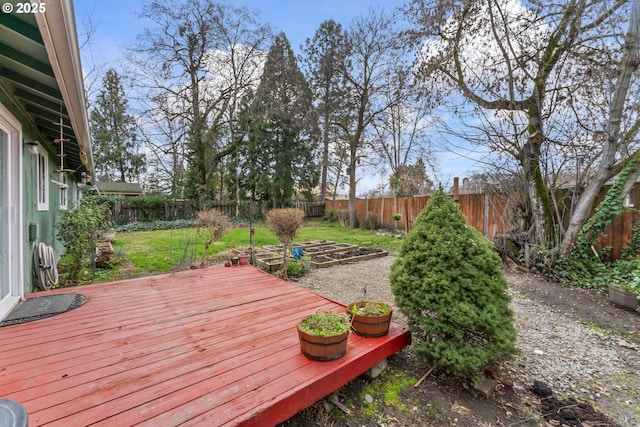 wooden deck featuring a fenced backyard and a garden