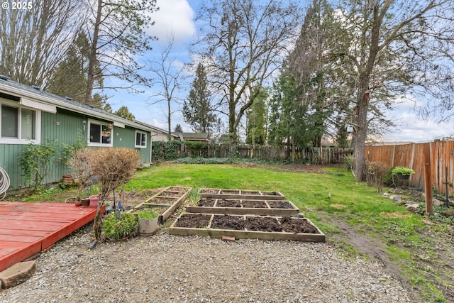 view of yard featuring a fenced backyard, a vegetable garden, and a wooden deck