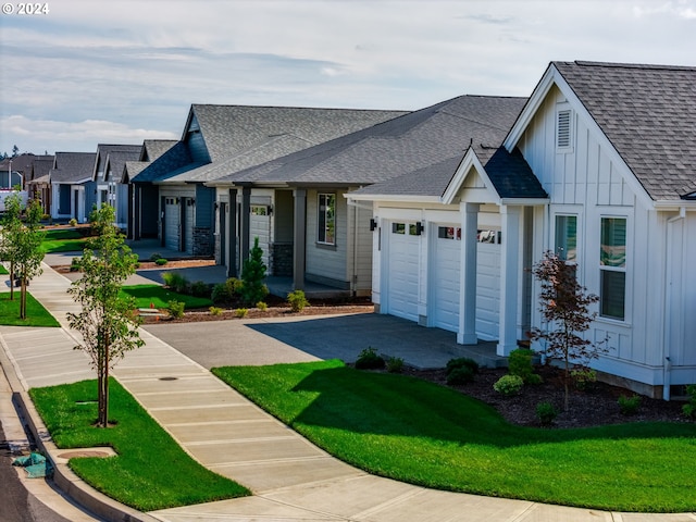 1819 S Maple St, Canby, OR 97013 - view of front of house featuring board and batten siding, driveway, roof with shingles, an attached garage, and a front lawn