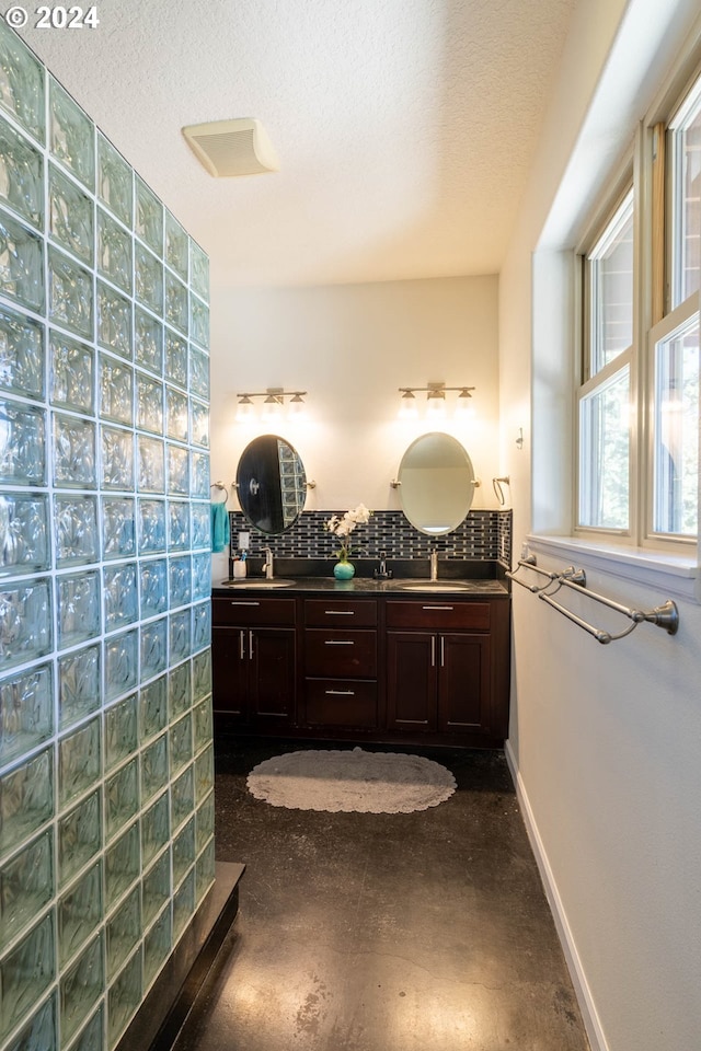 31367 Clarks Creek Rd, Mount Vernon, OR 97865 - bathroom featuring tasteful backsplash, double vanity, a textured ceiling, and baseboards