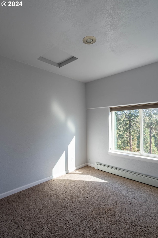 carpeted spare room with a baseboard radiator