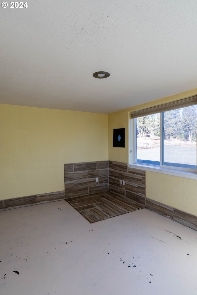 spare room featuring a textured ceiling and concrete floors