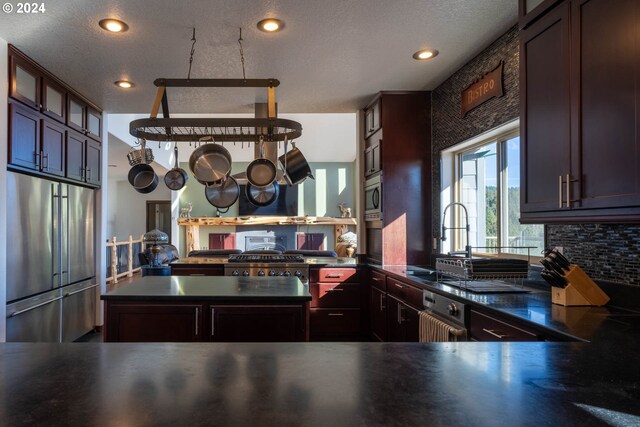 31367 Clarks Creek Rd, Mount Vernon, OR 97865 - kitchen featuring appliances with stainless steel finishes, dark countertops, recessed lighting, glass insert cabinets, and decorative backsplash