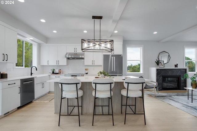 kitchen featuring a center island, stainless steel appliances, and white cabinets