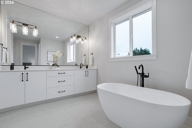 bathroom with a tub and vanity