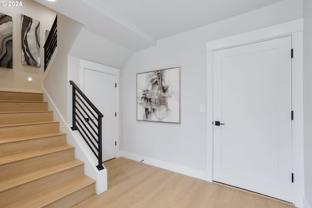 entryway with lofted ceiling and light hardwood / wood-style flooring