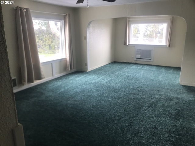 unfurnished room with carpet floors, a wall mounted air conditioner, and ceiling fan