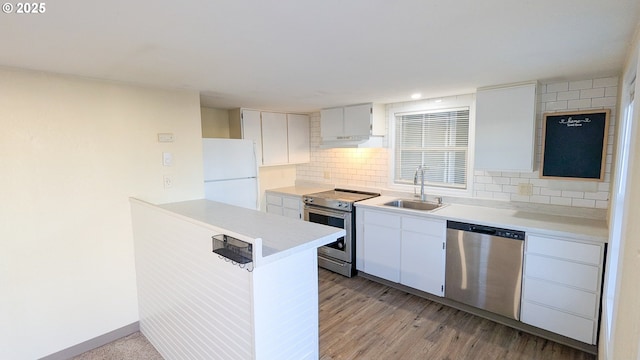 kitchen featuring sink, light wood-type flooring, appliances with stainless steel finishes, decorative backsplash, and white cabinets