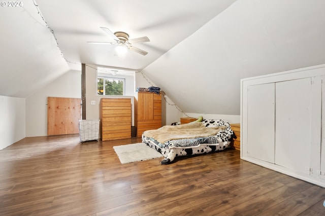 bedroom with hardwood / wood-style floors, ceiling fan, a closet, and vaulted ceiling