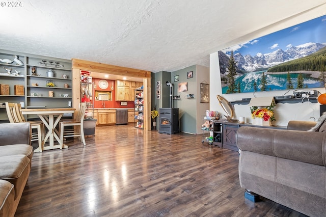 living room with a wood stove, dark hardwood / wood-style floors, and a textured ceiling