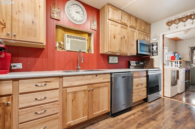 kitchen featuring sink, dark hardwood / wood-style floors, light brown cabinetry, stainless steel appliances, and washing machine and clothes dryer