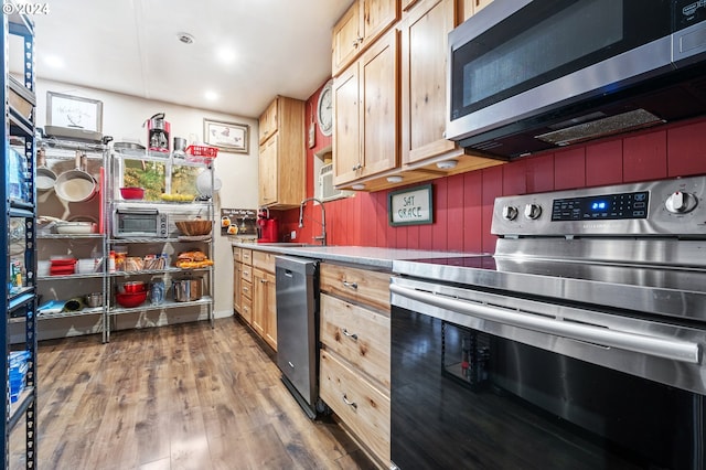 kitchen with sink, dark hardwood / wood-style flooring, stainless steel appliances, and light brown cabinetry