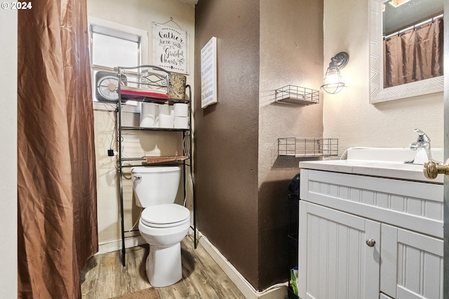 bathroom with toilet, vanity, and hardwood / wood-style flooring