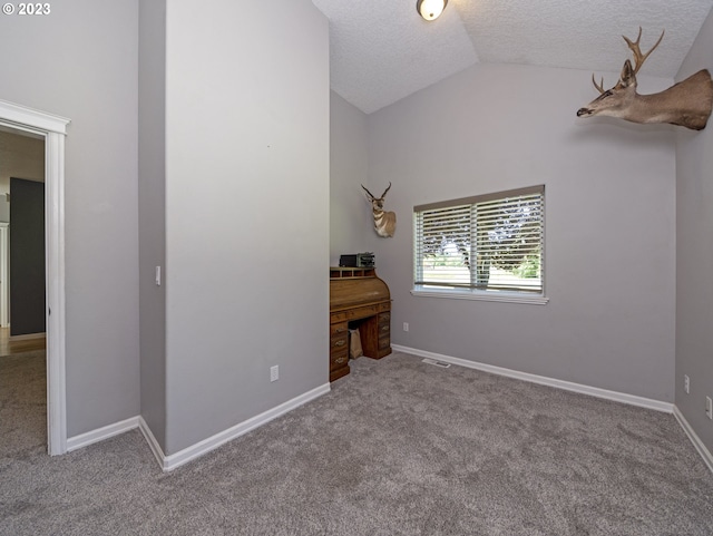 unfurnished bedroom featuring lofted ceiling, light carpet, and a textured ceiling