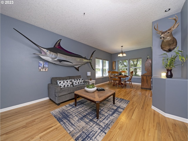 living room with a textured ceiling, an inviting chandelier, and hardwood / wood-style flooring