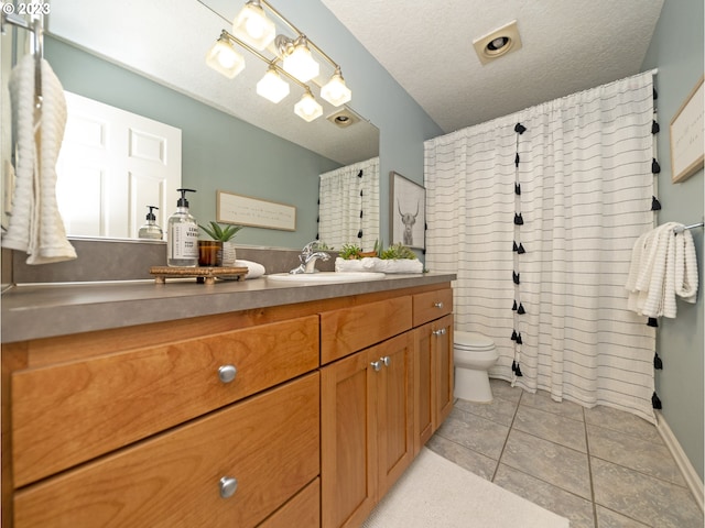 bathroom with a textured ceiling, toilet, tile patterned floors, and vanity