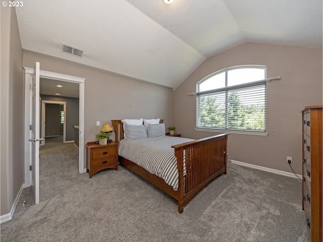 bedroom featuring lofted ceiling, carpet floors, and a textured ceiling