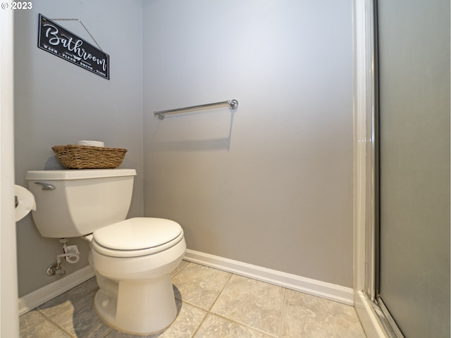 bathroom with toilet and tile patterned flooring