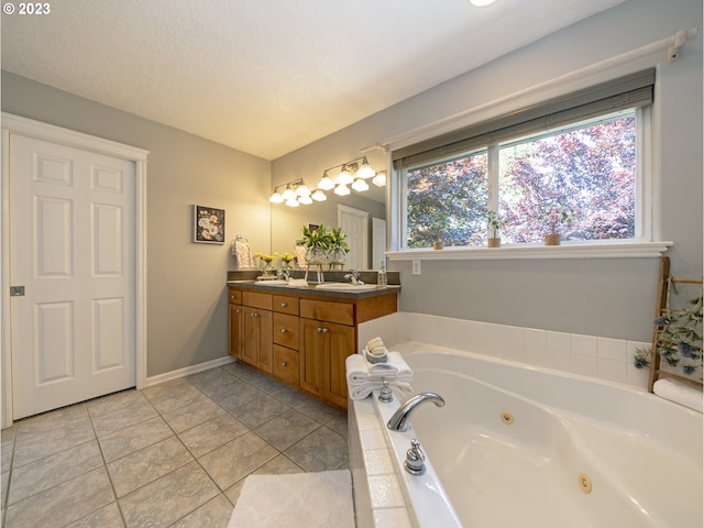 bathroom with a washtub, a textured ceiling, vanity, and tile patterned flooring