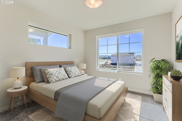 bedroom featuring carpet, multiple windows, and baseboards