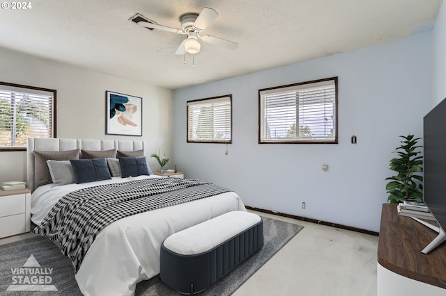 carpeted bedroom featuring multiple windows and ceiling fan