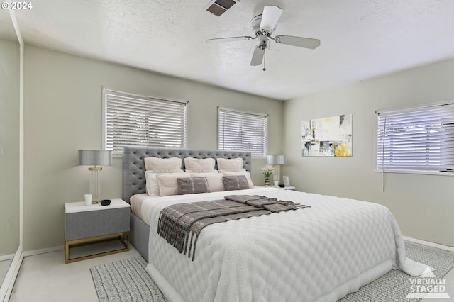 bedroom featuring ceiling fan, a textured ceiling, and light colored carpet