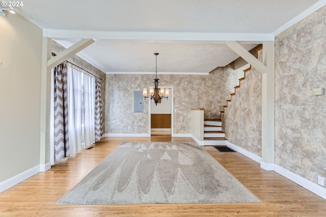 unfurnished dining area featuring ornamental molding, hardwood / wood-style floors, electric panel, and an inviting chandelier