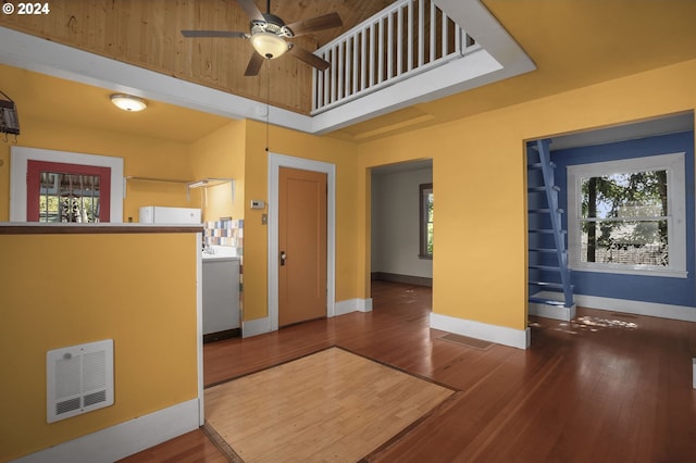 interior space with hardwood / wood-style flooring, ceiling fan, and a high ceiling