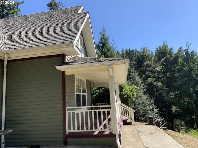 view of side of property featuring covered porch