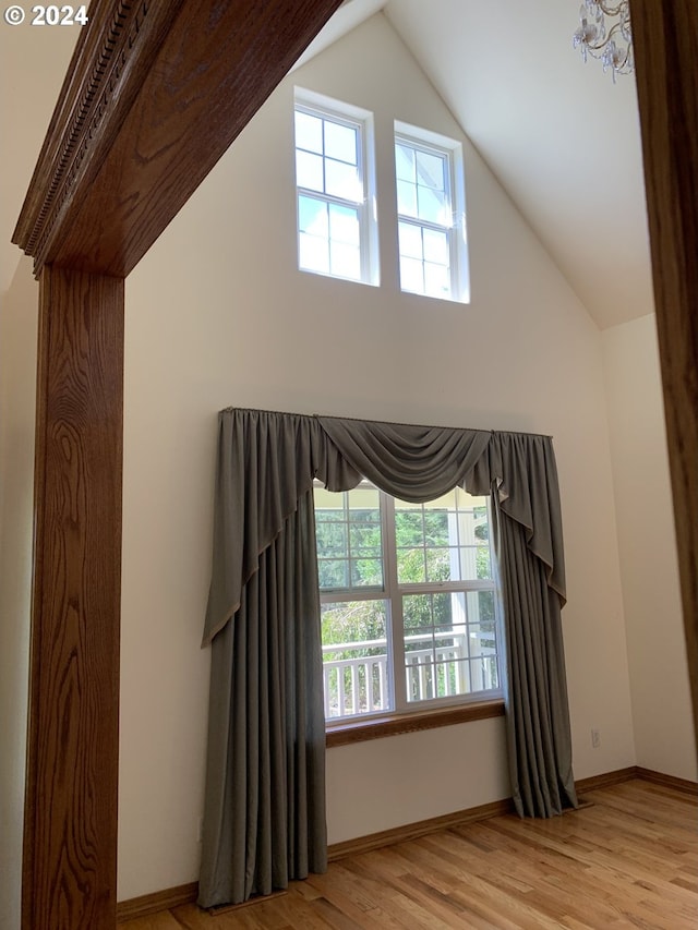 interior space with light wood-type flooring and vaulted ceiling