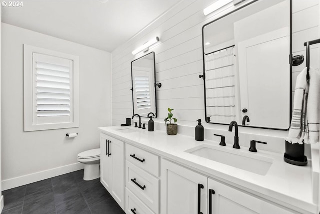 bathroom with double sink vanity, toilet, and tile floors