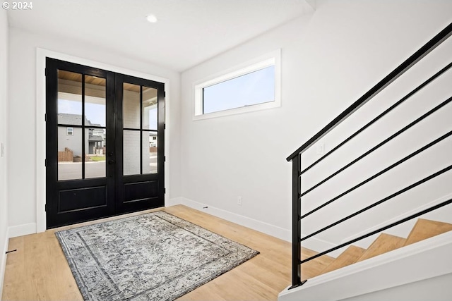 foyer entrance featuring light hardwood / wood-style flooring and french doors