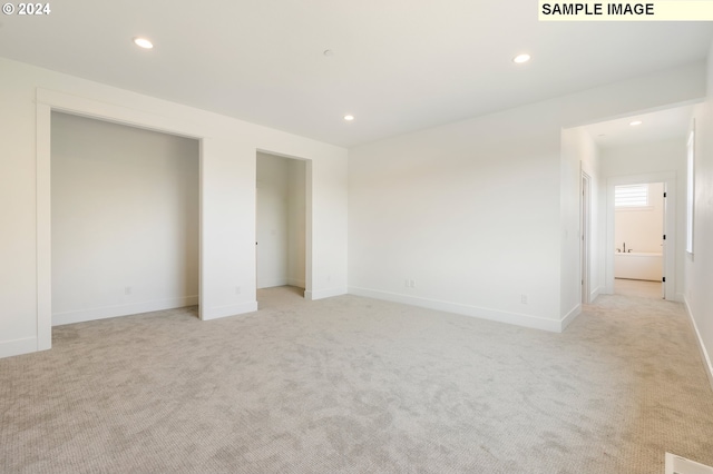 unfurnished bedroom with light carpet and ensuite bath