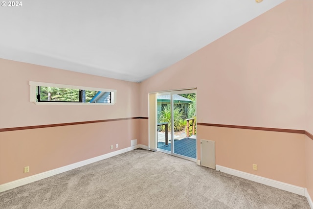 carpeted spare room with lofted ceiling