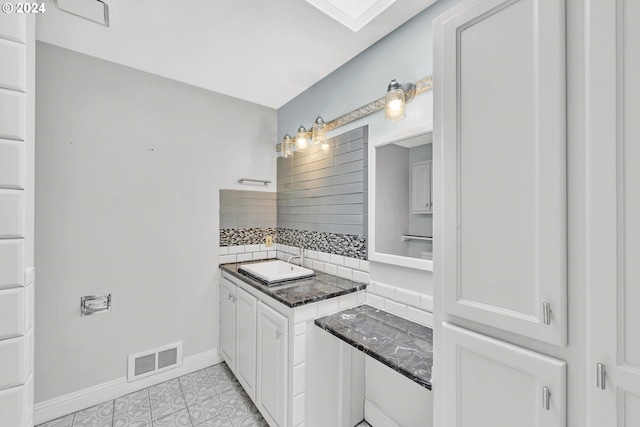 bathroom with tasteful backsplash, vanity, and tile patterned flooring