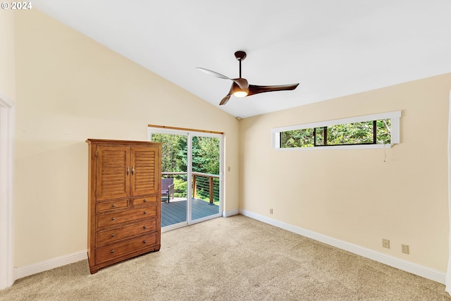 unfurnished bedroom featuring multiple windows, access to outside, lofted ceiling, and ceiling fan