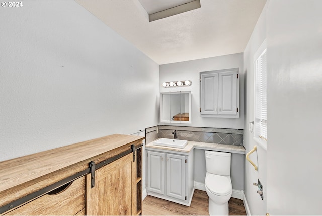 bathroom with vanity, hardwood / wood-style flooring, and toilet