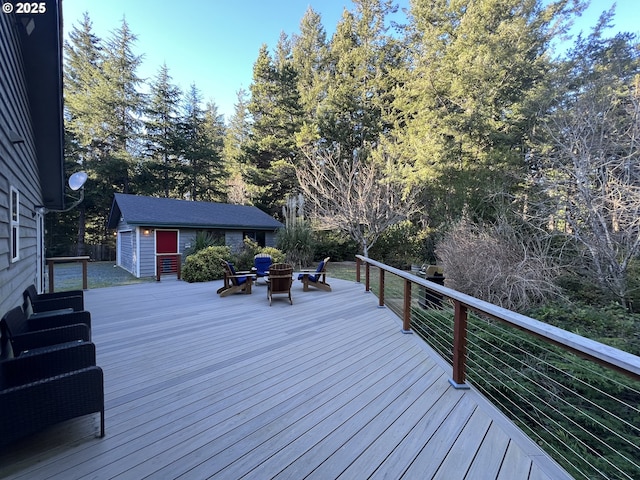 deck featuring a grill, a storage shed, and a fire pit