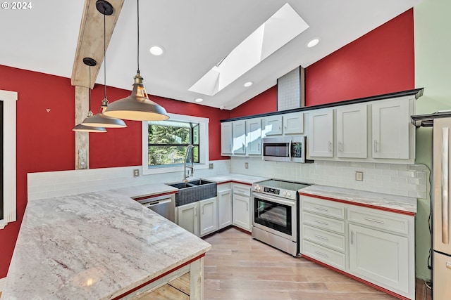 kitchen with pendant lighting, lofted ceiling with skylight, stainless steel appliances, decorative backsplash, and kitchen peninsula