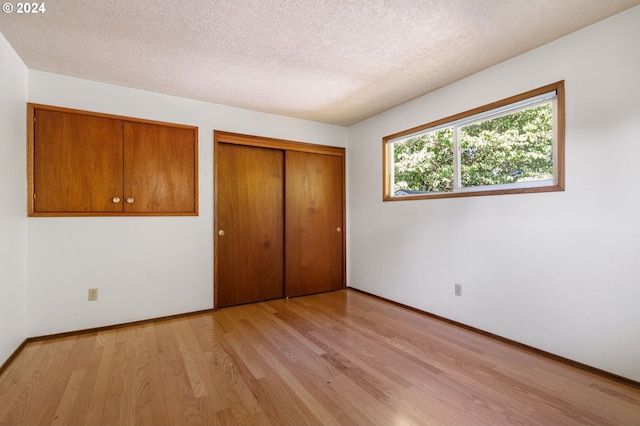 unfurnished bedroom with light hardwood / wood-style floors and a textured ceiling