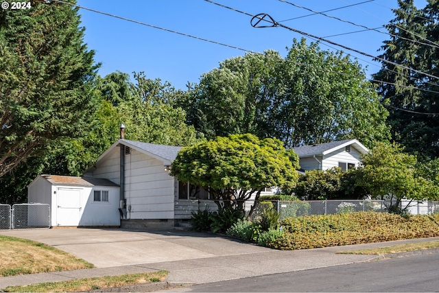 view of property hidden behind natural elements with a storage shed