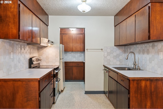 kitchen with a textured ceiling, stainless steel appliances, and sink