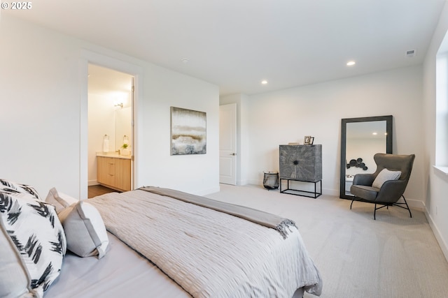 bedroom with ensuite bathroom and carpet floors