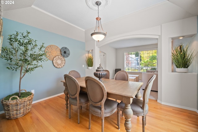 dining area featuring light wood-type flooring and a tray ceiling