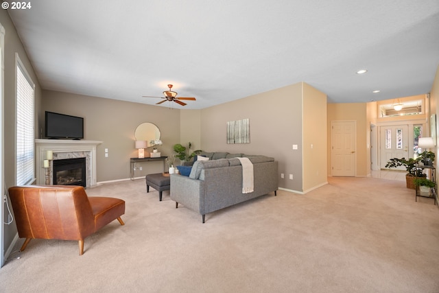 carpeted living room with a premium fireplace and ceiling fan