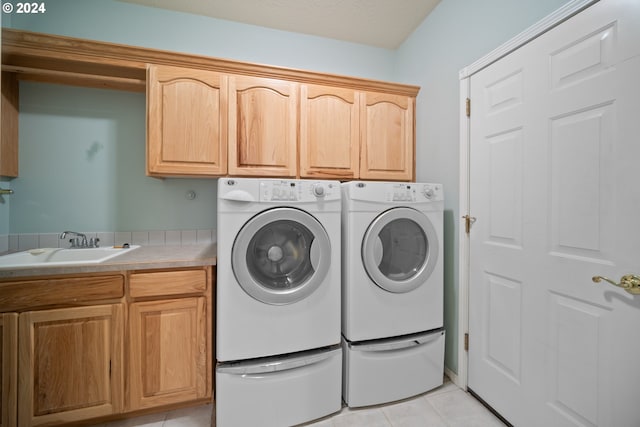 laundry room with sink, cabinets, washing machine and clothes dryer, and light tile patterned flooring