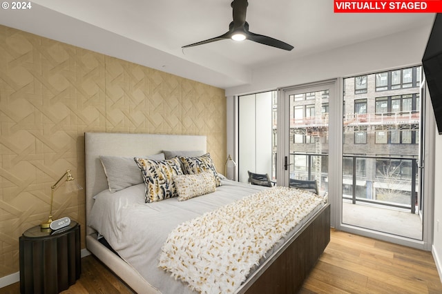 bedroom featuring light hardwood / wood-style flooring, ceiling fan, and access to outside