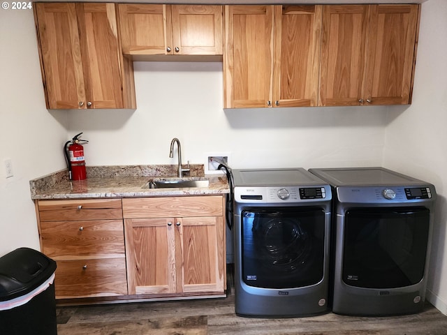 laundry area featuring cabinets, sink, washer and clothes dryer, and dark hardwood / wood-style flooring