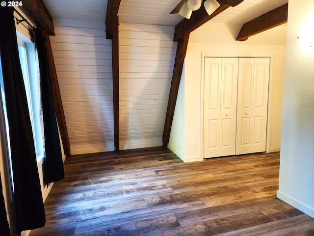 unfurnished bedroom with wood ceiling, a closet, ceiling fan, beamed ceiling, and dark hardwood / wood-style floors